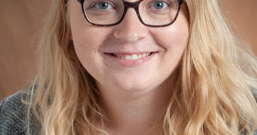 Headshot of Ashley Limesand, LPC, NCC, smiling, wearing dark-rimmed glasses.