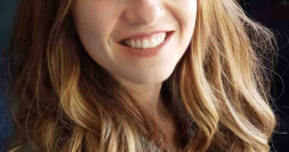 Headshot of a smiling woman with long blond hair.