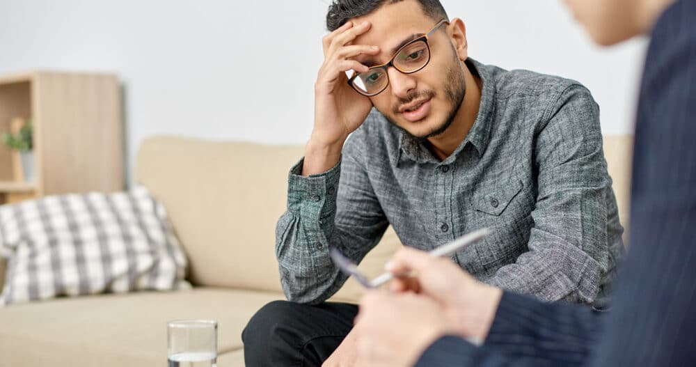 Man in therapy struggling with male mental health stigma