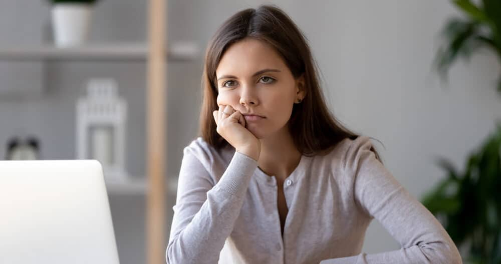 Woman sitting at computer showing signs of burnout