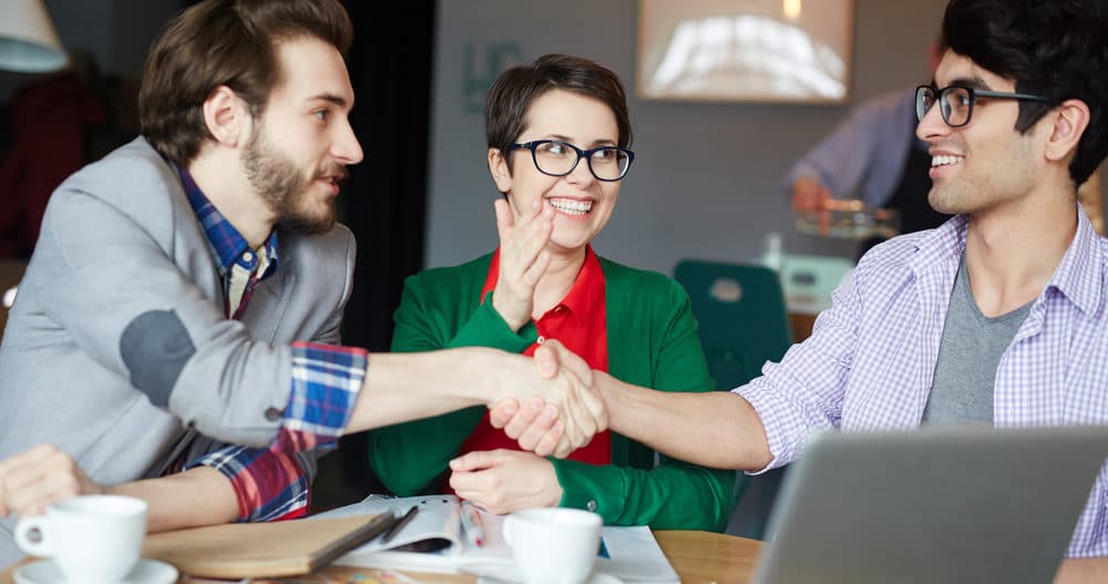 Three adult friends who have learned how to be friends spending time together and shaking hands