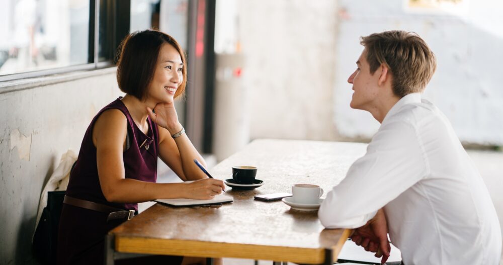 a man and a woman sitting at a table talking