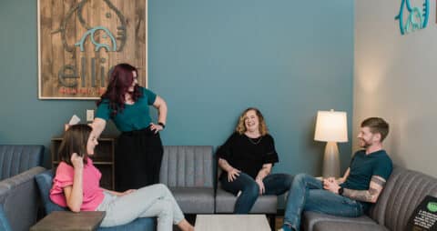 Four Ellie Mental Health professionals having a group discussion inside an Ellie Mental Health office