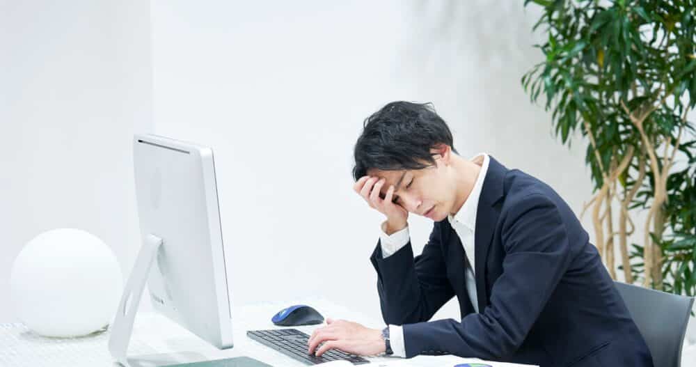 man on his office chair appearing to be in distress
