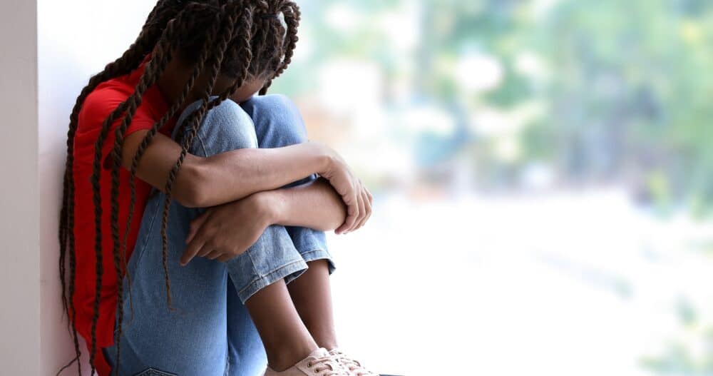child sitting on the floor with head down