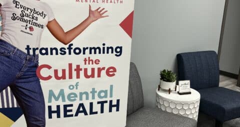 An photo of a large Transforming the Culture of Mental Health graphic display inside one of Ellie Mental Health clinics.