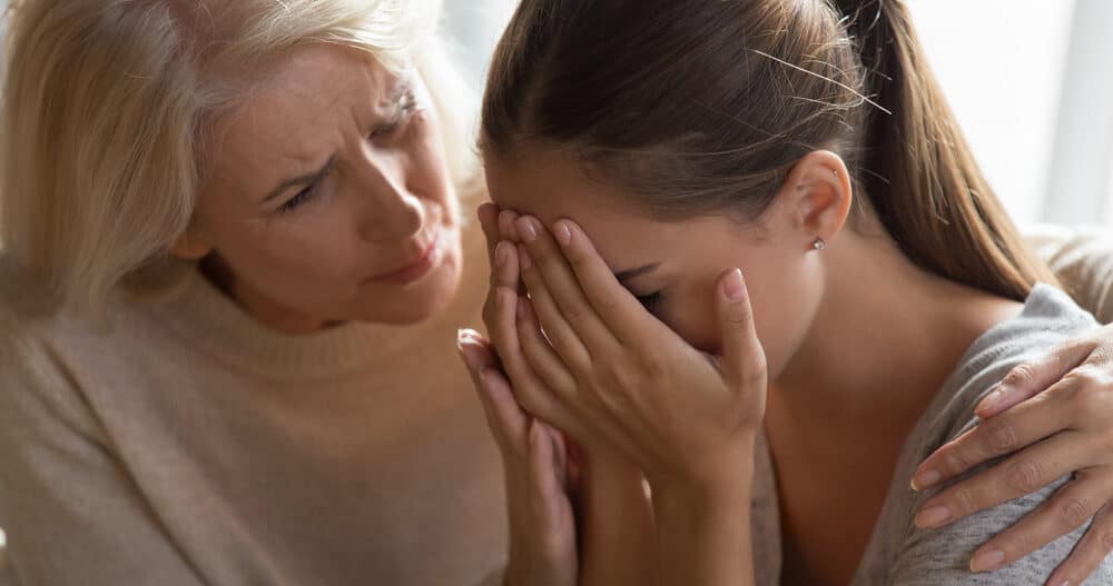 Loving Elderly 60 year old mom Embraces Crying Hurt Adult Offspring