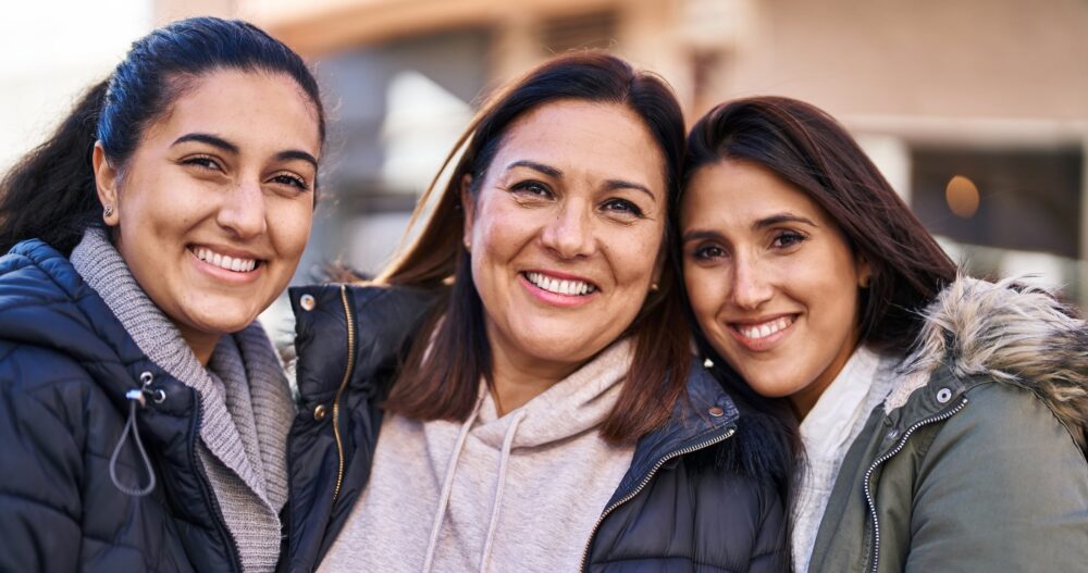 Three woman mother and daughters standing together at street