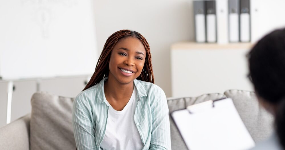 Young female client having consultation with psychologist