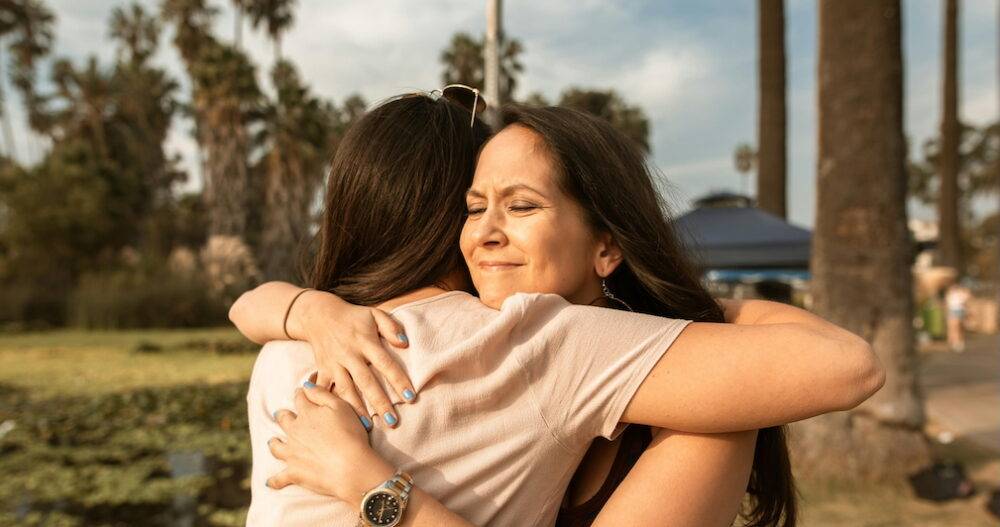Mom hugging her daughter outside